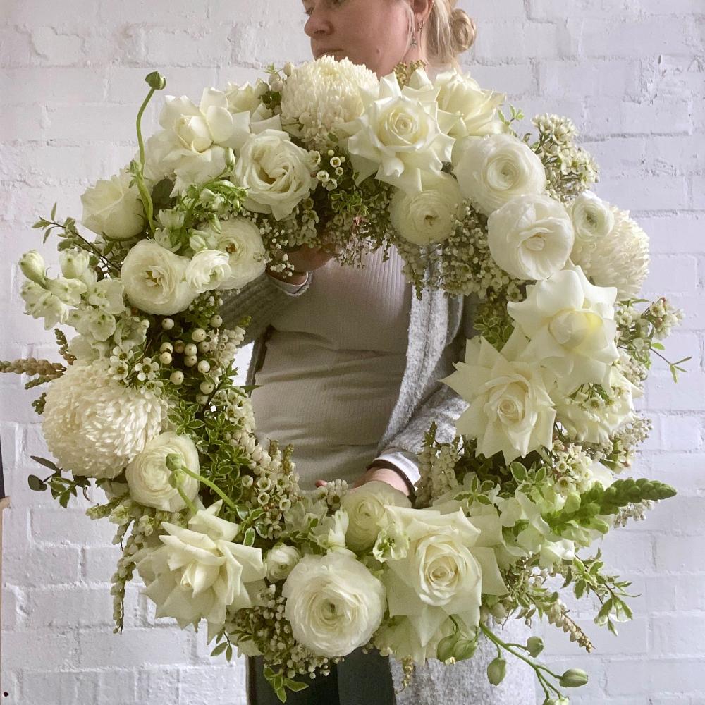 Florist holding Classic Funeral wreath
