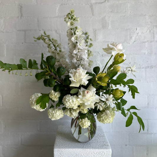 A beautiful seasonal white and green floral vase of flowers.