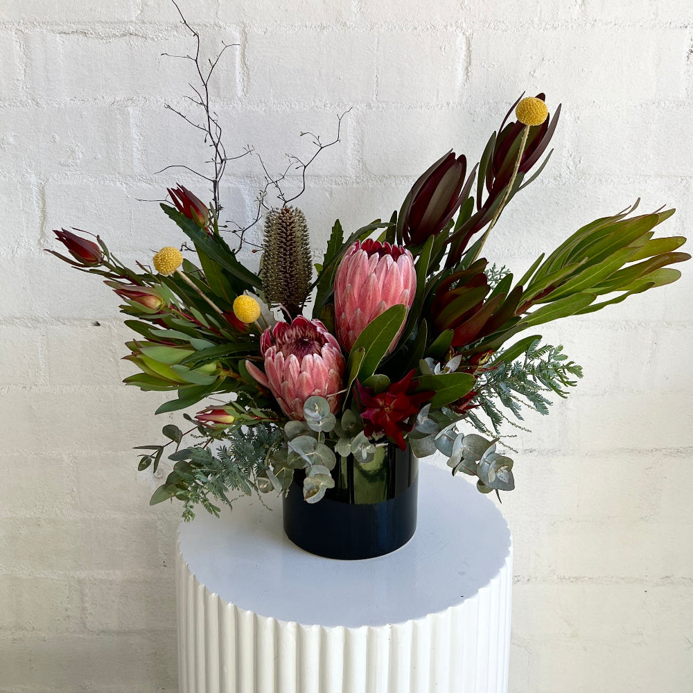 Native flowers in a black ceramic vase - banksias protea gum