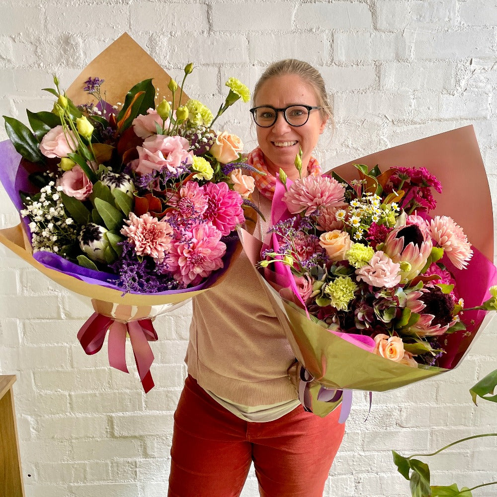 Florist holding two mixed flower bouquets