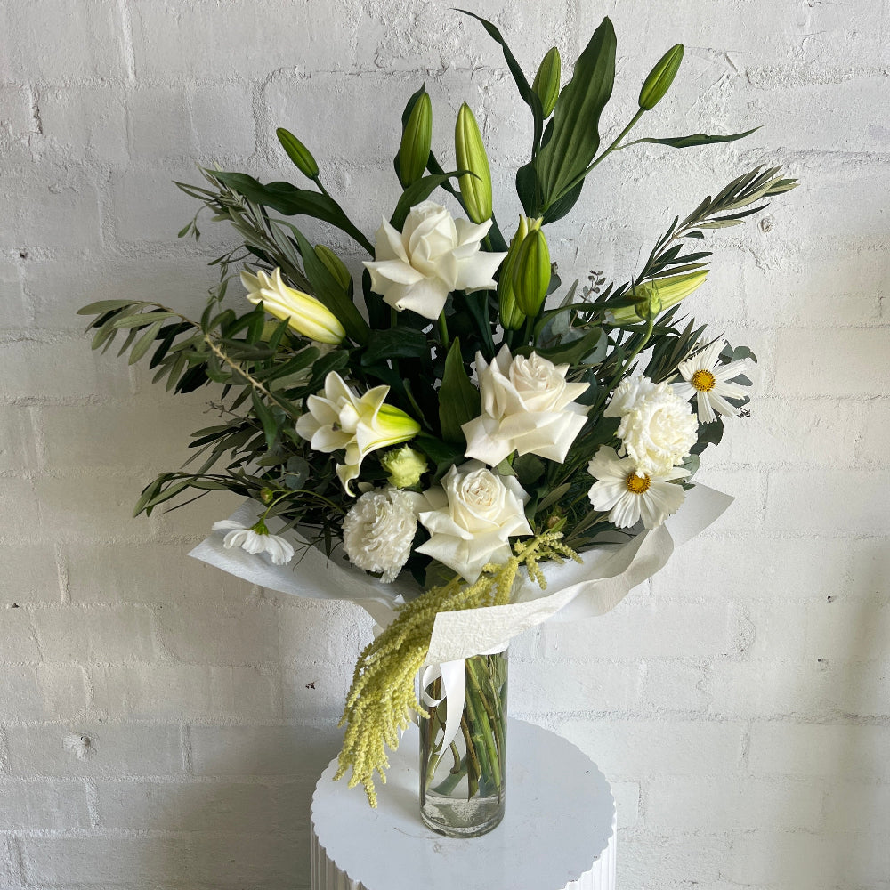 White & green arrangement of flowers in a glass vase