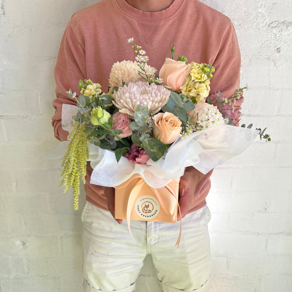 Pastel flower arrangement in a peach box
