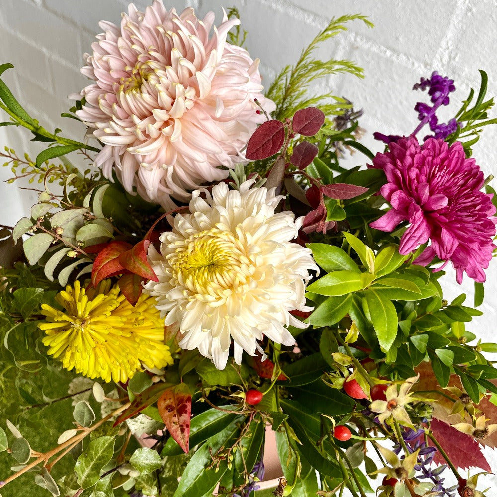 close up of bouquet including Disbuds, chrysanthemums and garden foliage