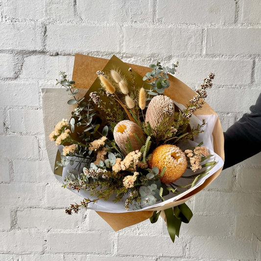 Australian native flowers gift wrapped in brown craft paper with a green ribben