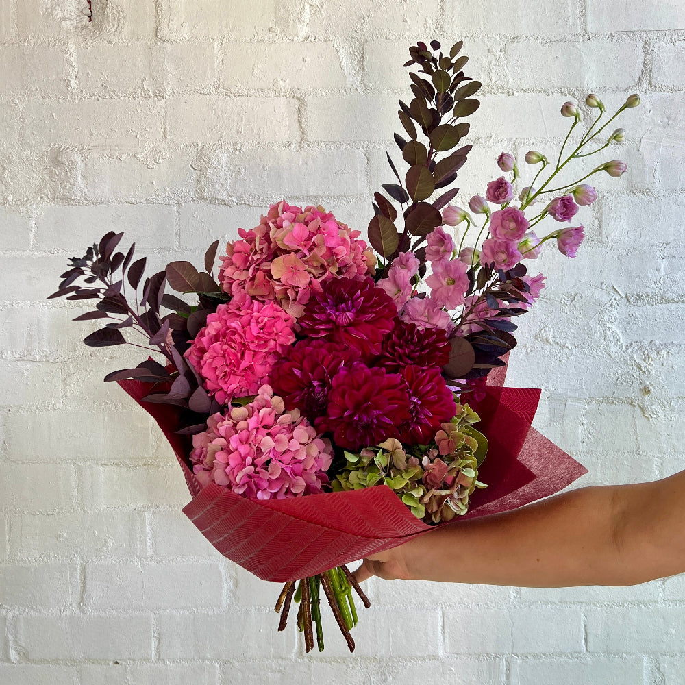 A mixed flower bouquet of reds, pinks and green flowers for valentines day