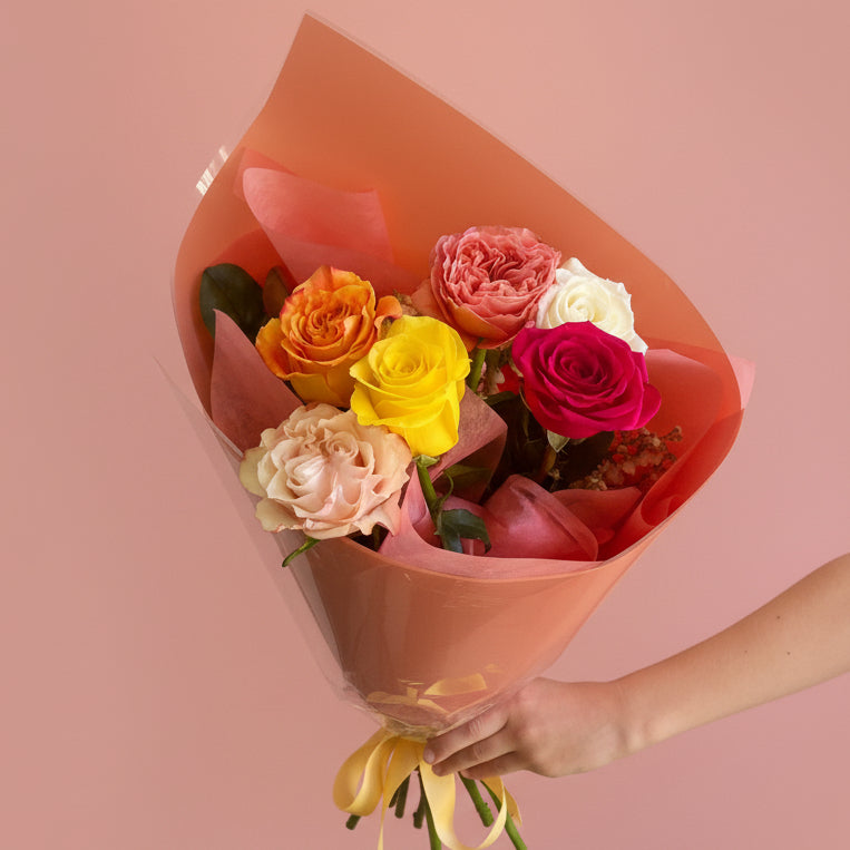 a bunch of Locally sourced roses in mixed colours wrapped in rose gold wrapping
