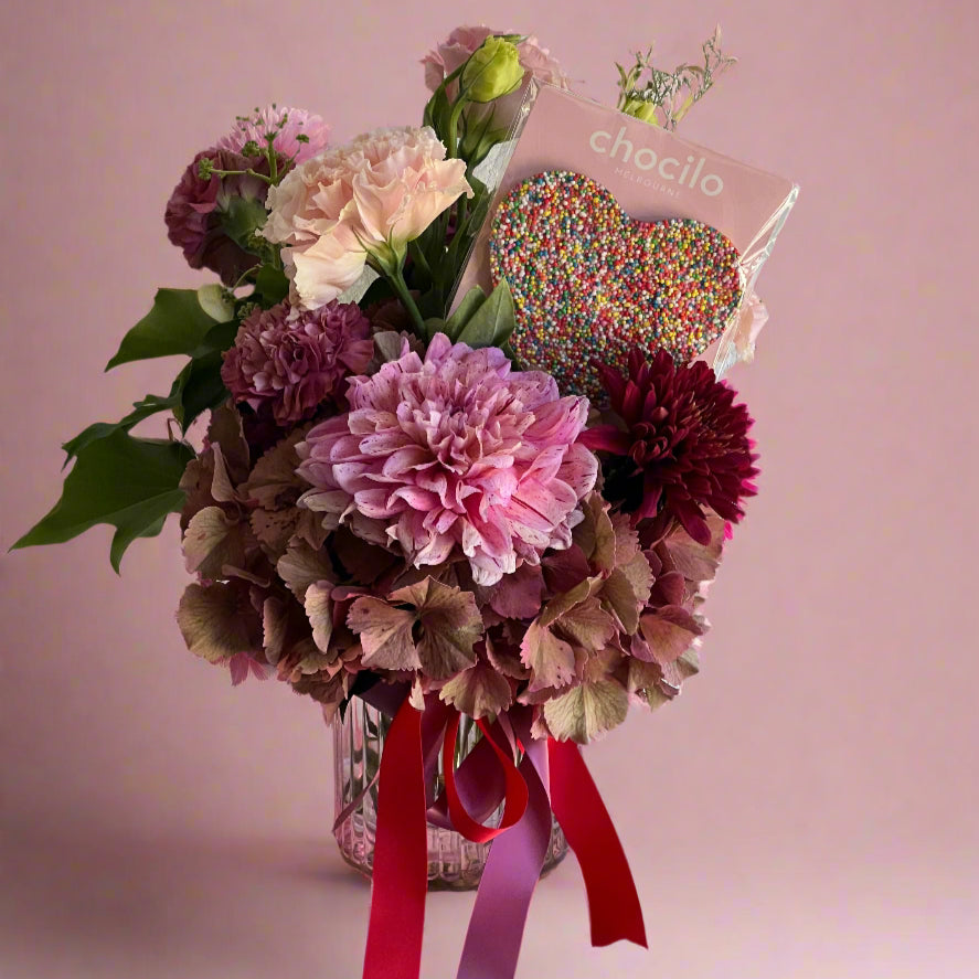 Pink & red valentines day vase arrangement with dahlias, hydrangeas and a chocolate heart