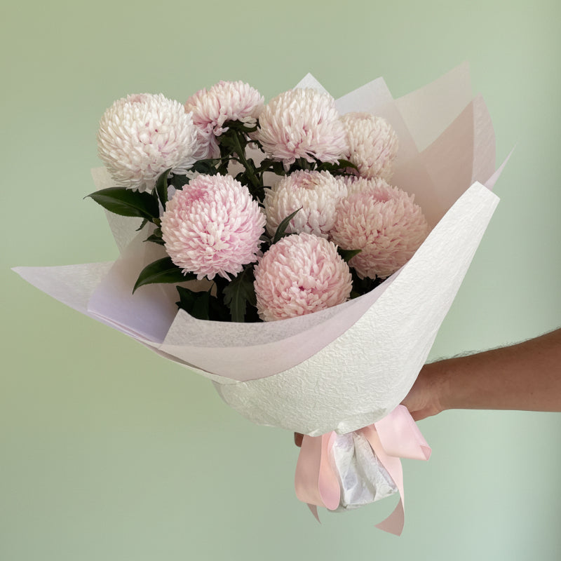 double bunch of fluffy blush pink disbuds wrapped in white wrapping and a pink bow