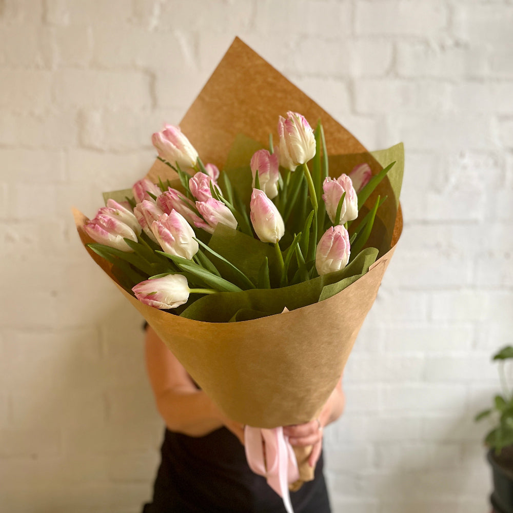 florist holding wrapped Tulips