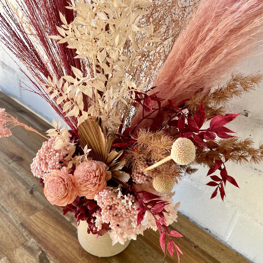 Dried, Preserved Flowers in ceramic vase. Bold pinks
