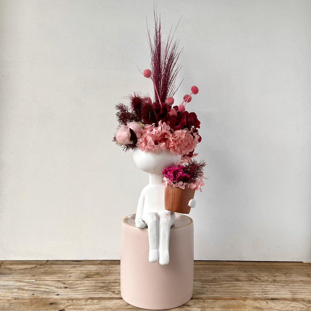 little man vase holding plant - preserved flower arrangement