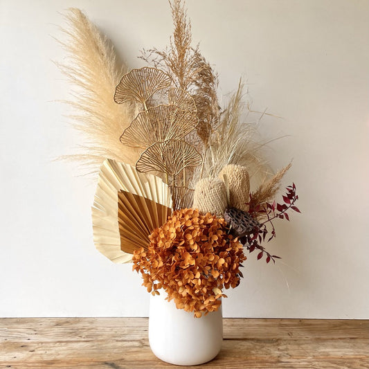 Preserved flower arrangement with deep rust tones